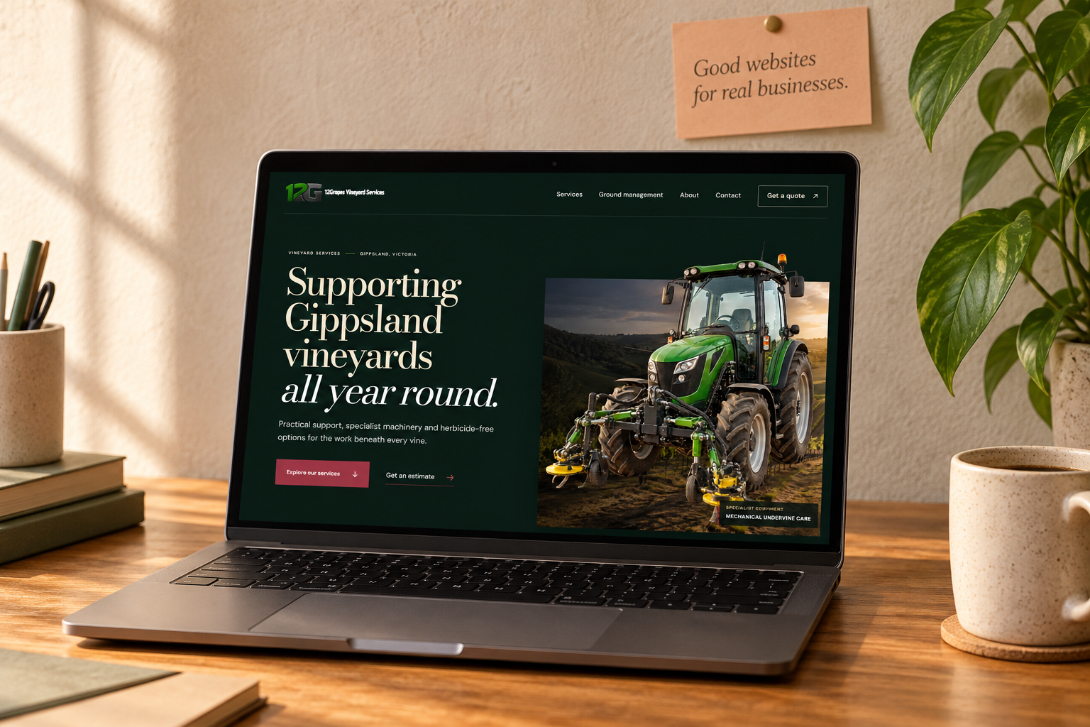 A laptop displaying the 12Grapes vineyard website in a warm studio workspace